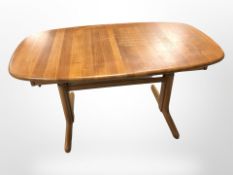 A contemporary Danish shaped teak extending dining table with internal leaf,