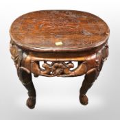 An oriental heavily carved hardwood oval plant stand,