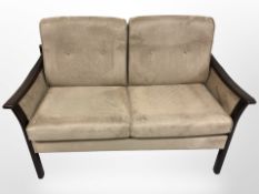 A late 20th century Danish two seater wooden framed settee in cinnamon coloured suede upholstery,