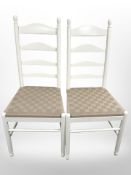 A pair of contemporary painted ladder back kitchen chairs with webbed seats.