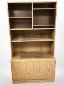 A 20th century Danish stained oak open bookcase fitted with cupboards,