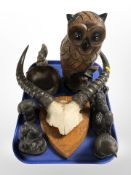 A pair of animal horns mounted on oak shield, four resin figures,