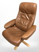 A late 20th century Danish stitched tan leather swivel armchair on bentwood support