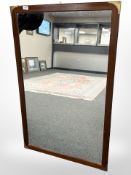 A teak-framed mirror with brass corners, 69cm x 109cm.