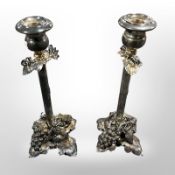 An ornate pair of silver plated grape and vine pattern candlesticks,