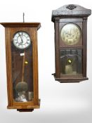 Two continental oak eight day wall clocks with pendulums,