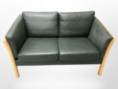 A late 20th century Danish dark green stitched leather wooden framed two seater settee,