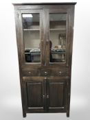 A contemporary stained pine glazed door cabinet, 90cm x 40cm x 190cm.