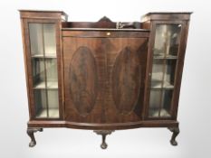 A 1920s mahogany bow front display cabinet on claw and ball feet, 151cm x 40cm x 132cm.