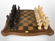 An inlaid wooden chess board and resin pieces,