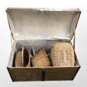An early-20th century wooden-bound domed trunk containing several wicker baskets.
