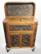 A 20th century oriental heavily carved camphor wood drinks cabinet, 85cm x 40cm x 99cm.