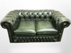 A Chesterfield green buttoned leather two seater club settee, 150cm x 87cm x 67cm.