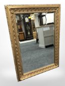 An ornate reproduction gilt over mantle mirror, 92cm x 67cm.