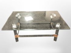 A contemporary bevelled glass rectangular coffee table on chrome and stitched leather support,