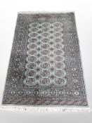 A Lahore Bokhara rug, Pakistan, the turquoise field with three columns of guls,