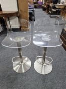 A pair of aluminium and perspex rise and fall stools