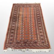 A Turkoman rug, Afghanistan, the terracotta field with two columns of guls,
