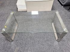A modern chrome and glass coffee table,
