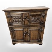 A reproduction carved oak side cabinet,