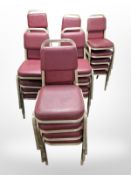 Twenty-seven brushed metal and red stitched vinyl stacking chairs