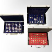 Three metal storage cases containing various world coins.