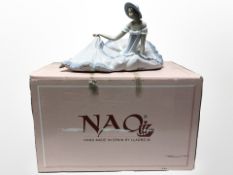 A Nao figure of a seated lady in large flowing dress, No. 1265, with original box.