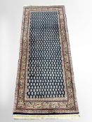 A Bidjar runner, North-West Iran, the dense indigo field with repeat boteh motif,