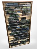 A collection of plastic scale model locomotives, in wood and perspex display cabinet,