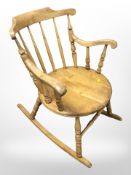 An early 20th century pine spindle back rocking chair