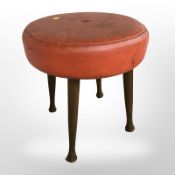 A 20th century circular footstool on turned tapering legs,
