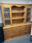 A modern pine dresser with leaded glass doors,