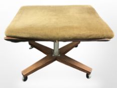 A 20th century teak and dralon X-framed stool on castors,
