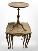 A carved walnut nest of three tables and a yew wood tripod table