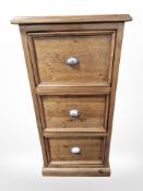 A stained pine three drawer filing chest,