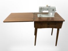 A Pfaff electric sewing machine in walnut table