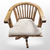 A modern stained pine swivel desk armchair,