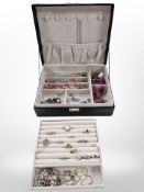 A contemporary jewellery box containing silver dress rings, charm bracelets,