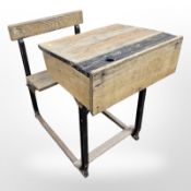 An early 20th century school desk with incorporated seat,