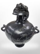 A Victorian bronze twin handled urn surmounted by a figure, height 29cm.