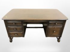 An Ercol stained elm twin pedestal desk,