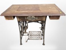 A Titan cast iron treadle sewing machine with walnut top,