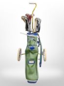 A golf trolley and bag containing Ben Sayers irons and other drivers