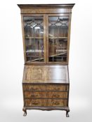 An Edwardian walnut bureau bookcase, on claw and ball feet,