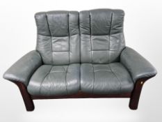 A contemporary stained wood framed two seater leather settee,