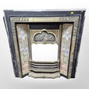 A reproduction cast iron and brass tiled fire insert 94 cm x 94 cm