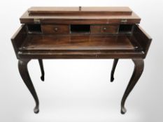 A reproduction hardwood writing table on cabriole legs,