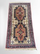 A Kurdish rug, with two large terracotta and indigo medallions on a cream floral field,