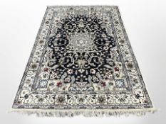 A Nain rug, Isfahan Province, Central Iran, the large ivory floral medallion against a black field,