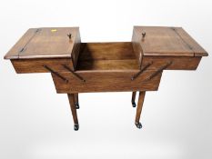 A beech concertina sewing box on castors,